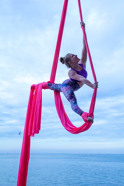 Woman performing a graceful yoga pose outdoors near water